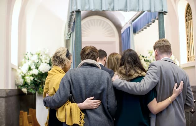 People huddled together in a church after a funeral. | Wrongful Death | The Sullivan Law Firm